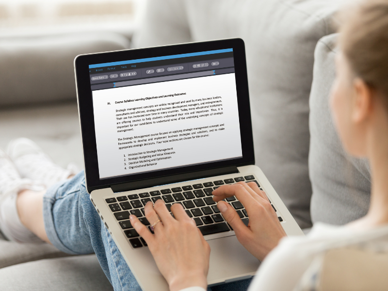 Close up of female sit on couch texting on laptop