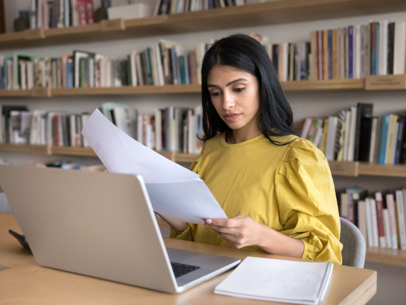Serious Indian student working on research paper in library